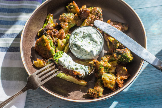 Fried broccoli in batter with spicy white sauce