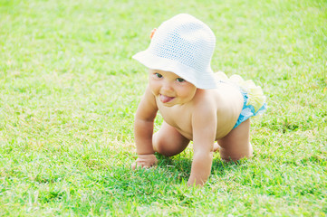 Fun mood. Cute little girl sitting on the grass on a sunny summer day