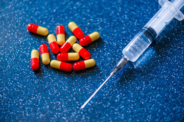 syringe and medication on a blue background