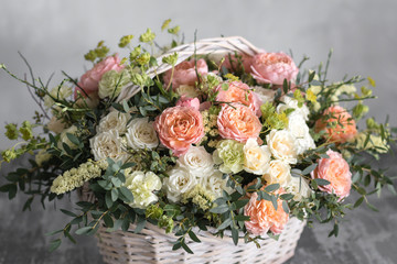 Beautiful flower composition a bouquet in a wicker basket. Floristry concept. Spring colors