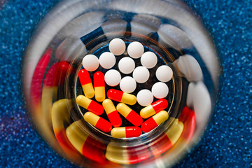 Capsules and tablets in a glass of