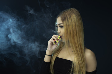 Obraz premium Young woman smoking electric cigarette