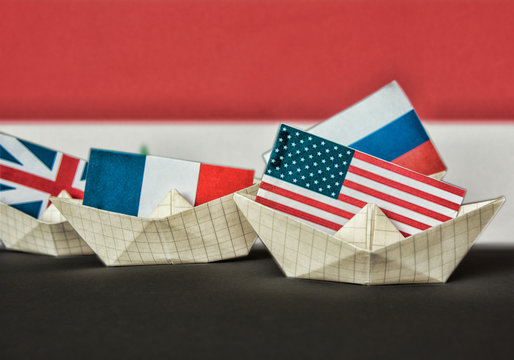 paper ship with Flags of USA and Russia. conflict in Syria sea, concept shipment or free trade agreement and membership. grunge image  