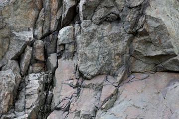 Granite rocks with faults, background of old stones, destruction of a granite wall, ecological...