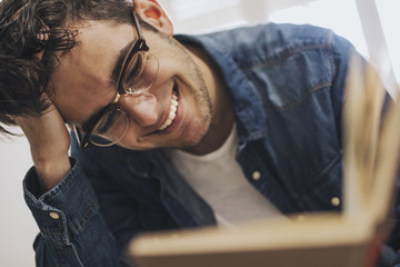 reading, smiling young laughing reading or studying a book