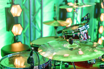 Fototapeta na wymiar Drum kit on stage. Close-up of plate, drums, sticks, in background scene spotlights