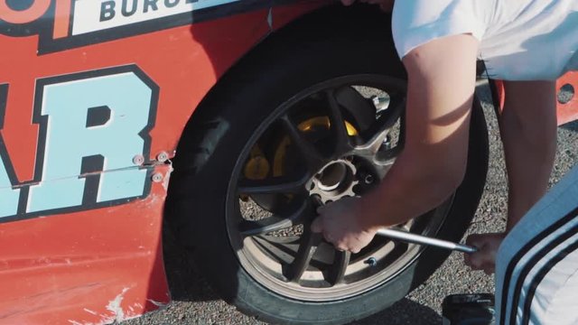Mechanics change the wheel on a racing car