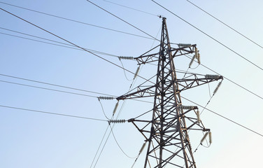 High-voltage tower, transmission line in sky background.