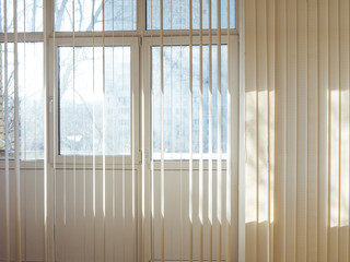 vertical jalousie blinds on the window on a sunny day, sunshine through window