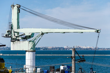 Fototapeta na wymiar large light crane against the backdrop of a seaport