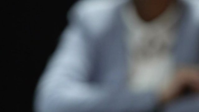 Woman showing stop gesture while man offering white envelope, bribe reject