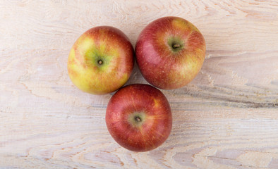 Red organic apples on wooden background