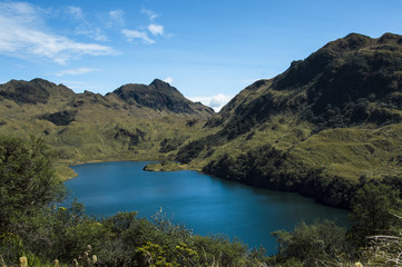 Fototapeta premium Una laguna azul alrededor de montañas verdes de los Andes