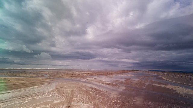 hyperlapse pov shot with a camera attached to the front of an off road vehicle driving over a flooded beach in the delta d'ebro park, spain