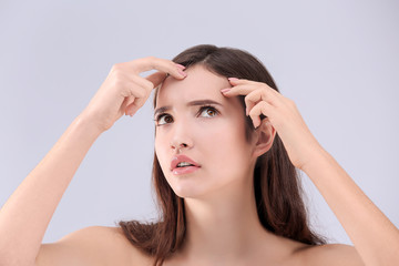 Naklejka premium Teenage girl with acne problem against grey background
