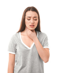 Fototapeta premium Young woman suffering from sore throat on white background
