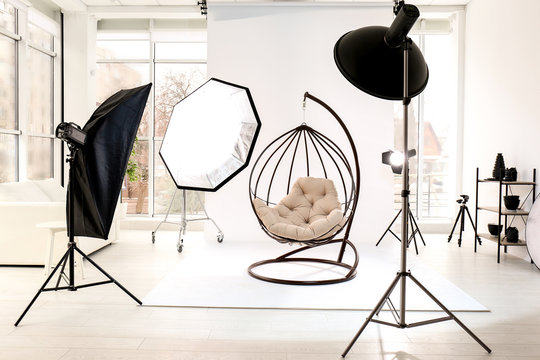 Hanging chair in photo studio with professional equipment
