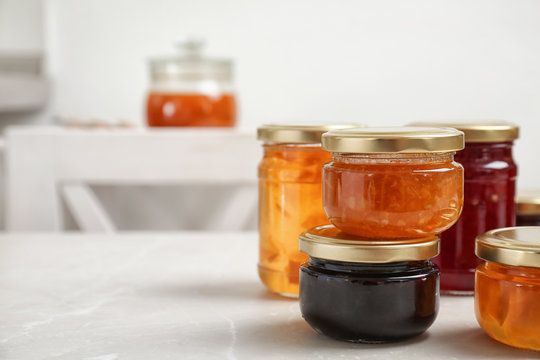 Jars with different sweet jam on table