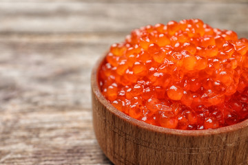 Bowl with delicious red caviar on table