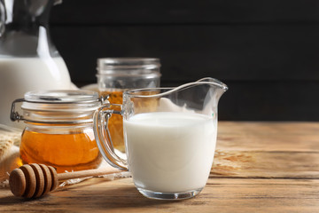 Beautiful composition with milk and honey on wooden table