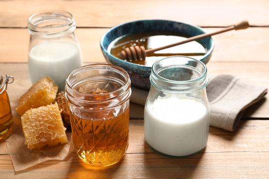 Composition with milk and honey on wooden background