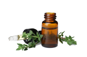 Bottle with thyme essential oil and fresh herb on white background