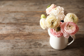 Vase with beautiful ranunculus flowers on wooden table