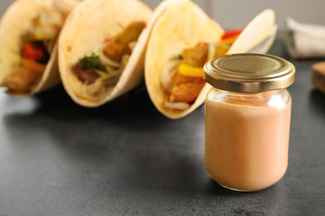 Tasty creamy sauce for fish taco in glass jar on kitchen table