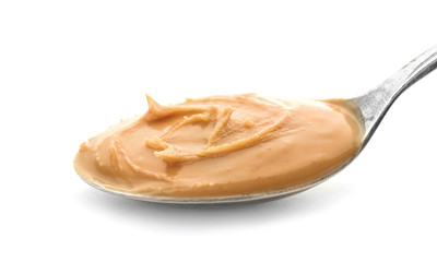 Creamy peanut butter in spoon on white background