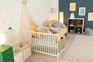 Stylish baby room interior with crib