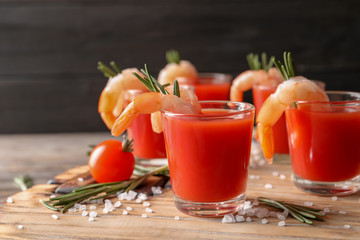 Delicious shrimp cocktail shots on wooden table