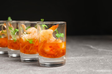 Delicious shrimp cocktail shots on grey table