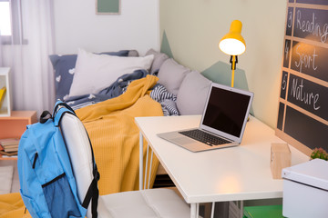 Modern child room interior with desk and laptop