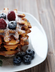 Blueberry waffles with raspberries and sugar powder for breakfast,