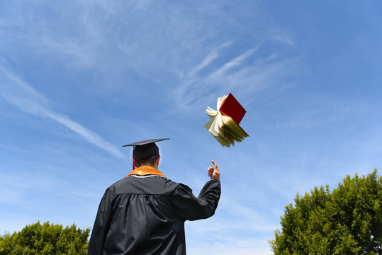 Graduate Tossing Book in the Air