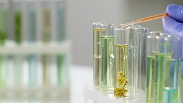 Scientist mixing different fluids to obtain active medication, slow-motion