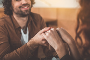 My love. Close up of happy young man and woman holding hands with gentleness. Focus on arms