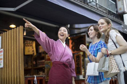 店員に道を教えてもらう外国人観光客