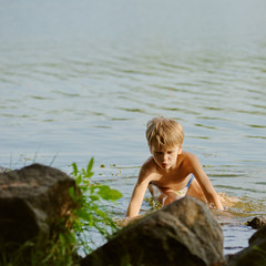 Young cute schoolboy playing near like on weekend. square aspect ratio