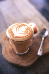 Cup of hot cappucino is on the wooden table