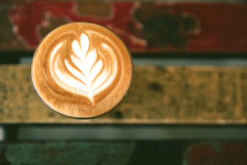 Cup of hot cappucino is on the wooden table