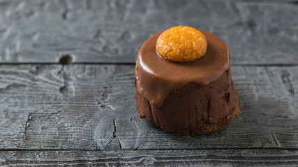 Fresh cake decorated with cookies on a dark rustic table.