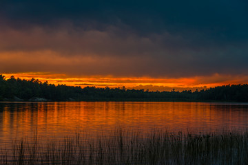 Sunset above forest lake