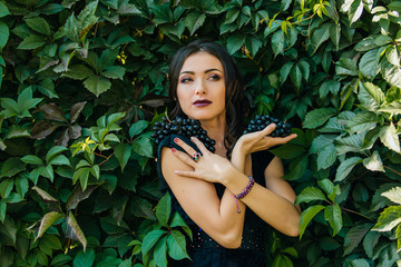 Portrait of young sexy brunette with black grapes. Copy Space.