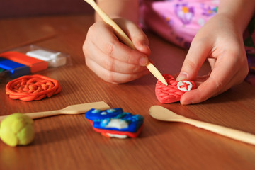 The hands of the child are molded from plasticine