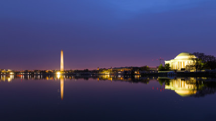 Naklejka premium Washington DC panorama around Tidal Basin at sunrise during cherry blossom. City landmarks with reflection in dark waters at dawn.
