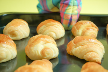 Image to pick up bread from an oven, bake bread in an oven. オーブンからパンを取り出す、パンをオーブンで焼くイメージ　黄色背景