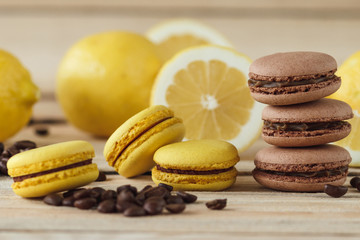 Yellow and brown french macarons with lemons and coffee beans on the wooden board