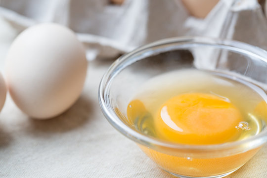 Fresh farm eggs. Egg yolk in glass bowl.