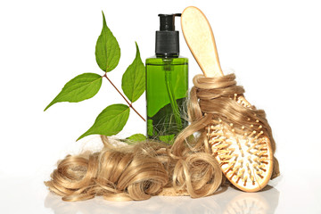 Fototapeta premium Natural Herbal Cosmetics for Hair. cosmetic with herbal extract, light curls and comb on white background. Bio green organic hair cosmetics